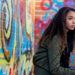 Teen girl in front of graffiti wall