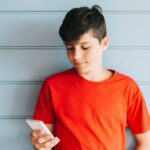 Teen boy using phone according to texting rules