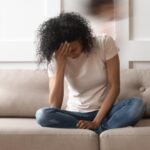 Mom sitting on couch with head in hands