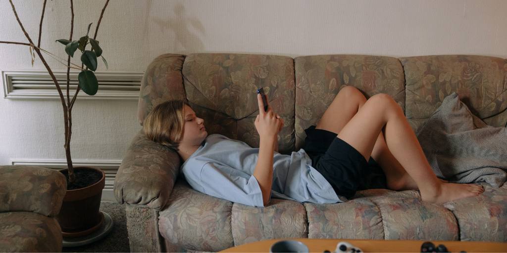 teen texting on couch